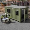 Portable site office container with three engineers in PPE reviewing project drawings outside