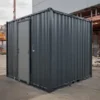 Anthracite grey portable toilet cabin placed at a building construction site
