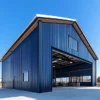 Navy pre-engineered building with an open clear-span bay and exposed steel roof frame on a concrete apron.