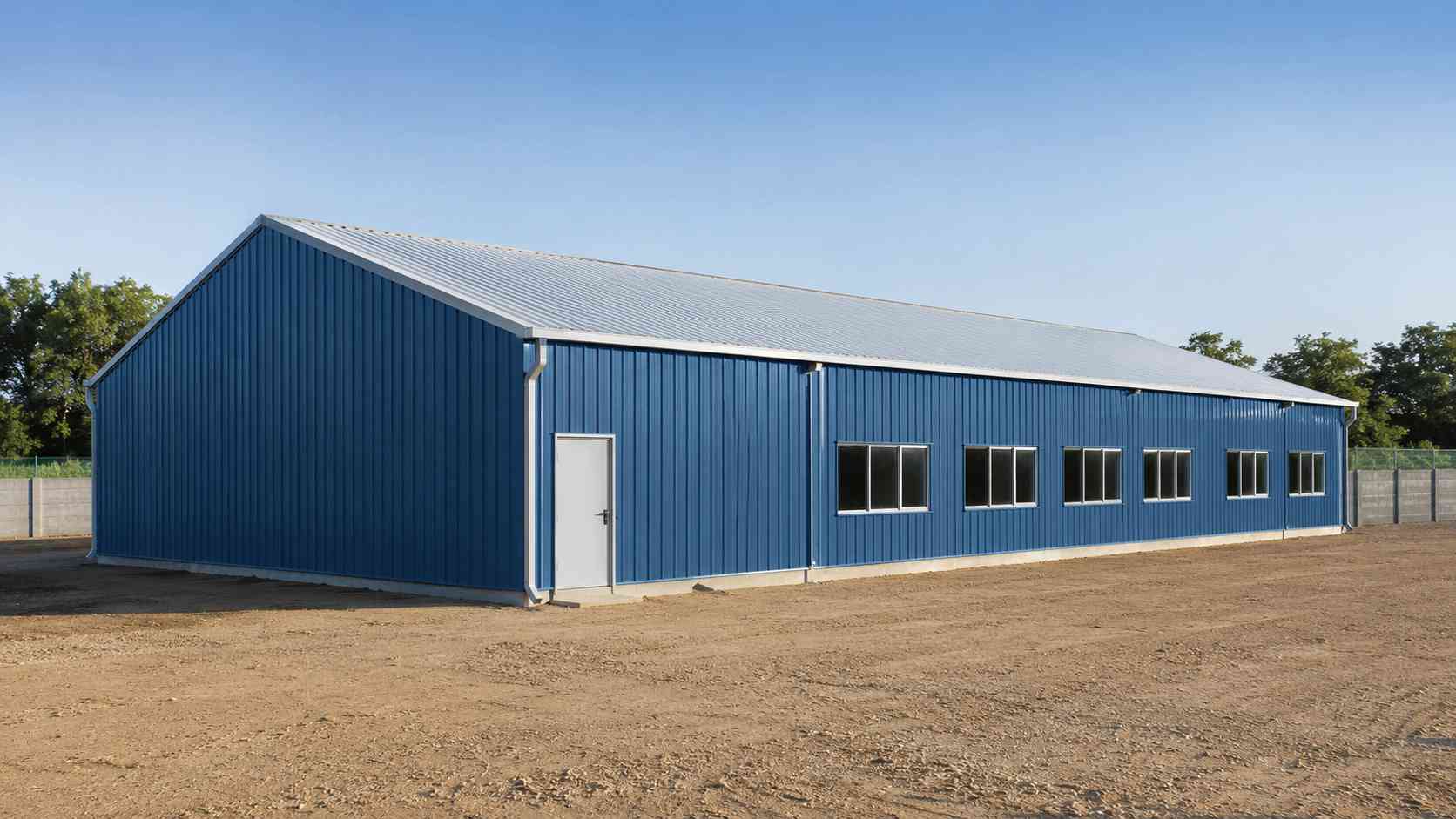 Steel-blue pre-engineered building supplied and erected on a cleared Indian industrial plot