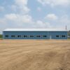 Long side elevation of a steel-blue pre-engineered building showing the full 120-foot length