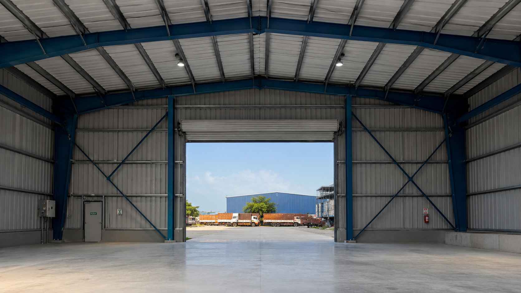 Structural steel portal frame inside a finished pre-engineered steel building with bolted column-rafter connections.