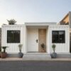 Front entrance of a white prebuilt container home with beige accent and porch steps.