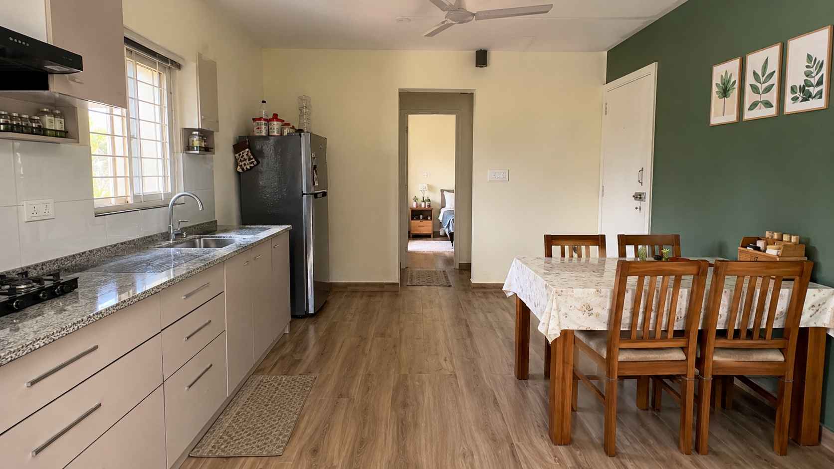 Factory-fitted kitchen inside a prebuilt container home with granite counter and green accent wall.