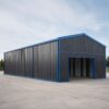 Long side elevation of a charcoal prefab building with blue trim and a covered entry bay.