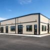 Beige prefab commercial building with windows and entry doors set up as a retail outlet.