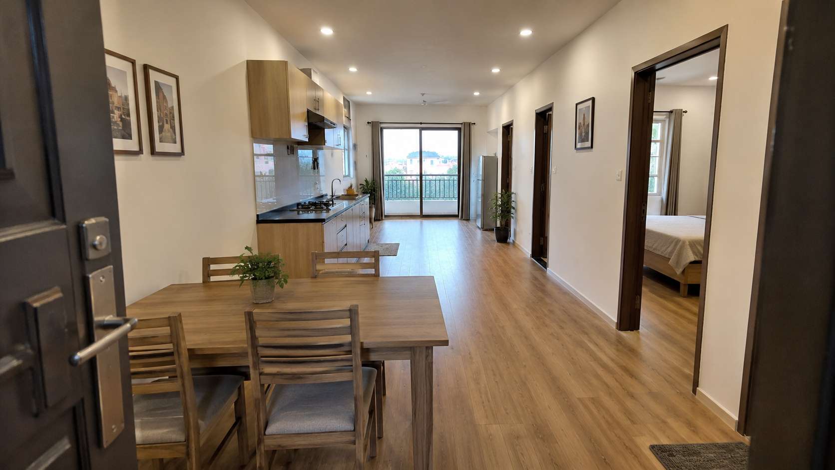 Through-the-door interior view of SAMAN prefab container home showing dining area, kitchen, bedroom doorway, and balcony slider in one frame.
