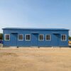 Front elevation of a SAMAN prefab labor camp dormitory block with three doors and six sliding windows