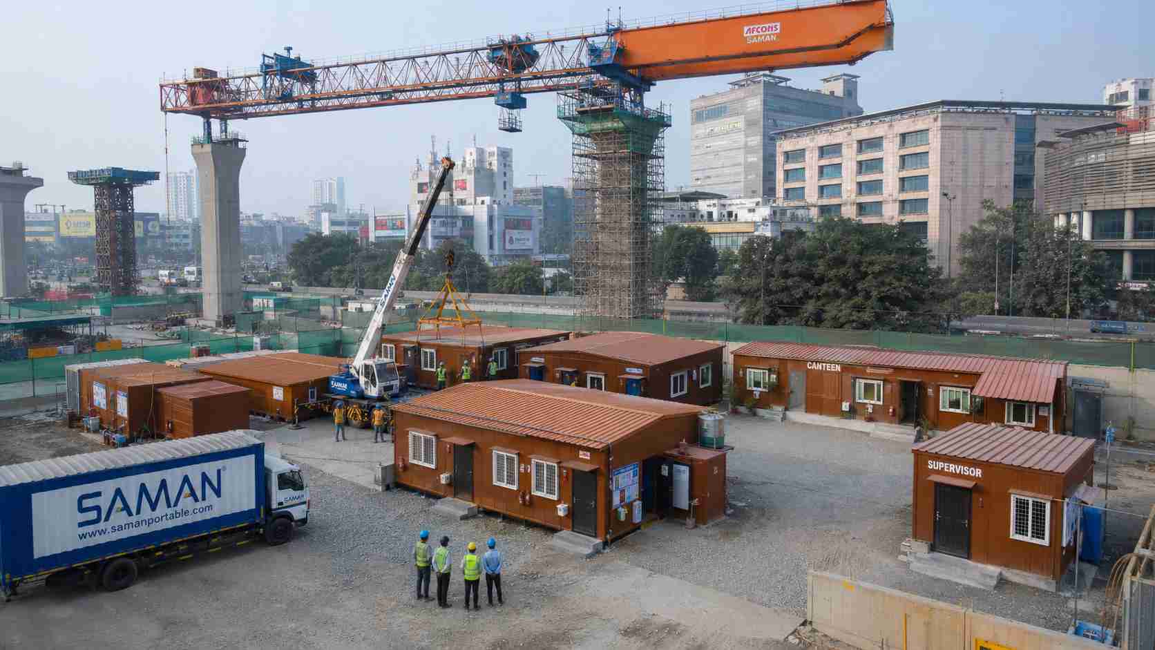 SAMAN prefab labor camp at an urban metro rail construction project with batch-delivery truck unloading on site