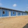 Side view of a single-storey prefab labour colony dormitory block