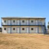 Two-storey prefab labour colony block with external staircase and upper walkway