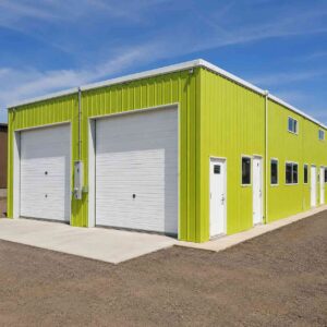 Steel-blue prefab manufacturing building by SAMAN, 90 by 36 feet, in an industrial estate.