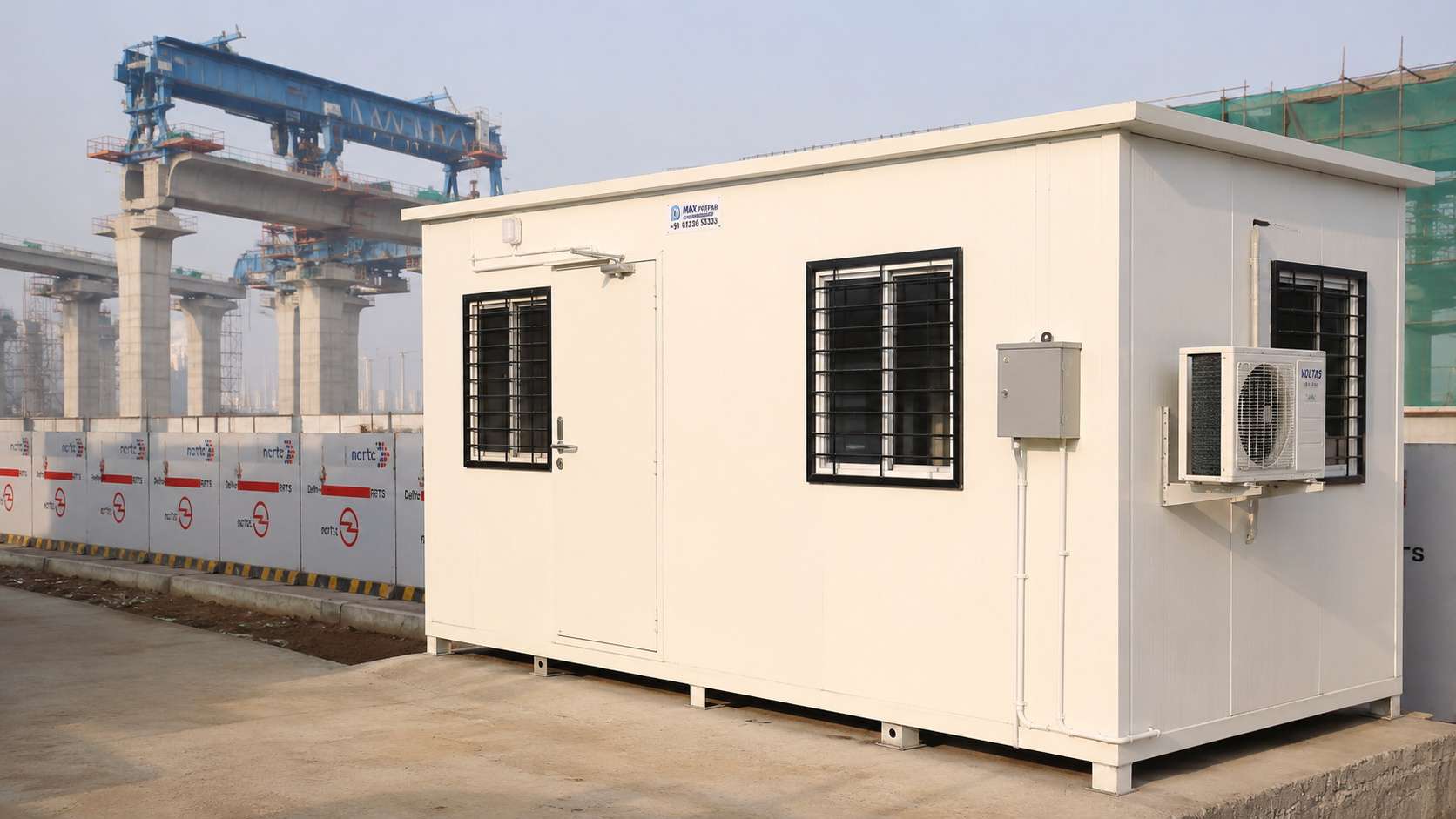 Pure White prefab mobile office beside a metro rail viaduct under construction with launching gantry visible.