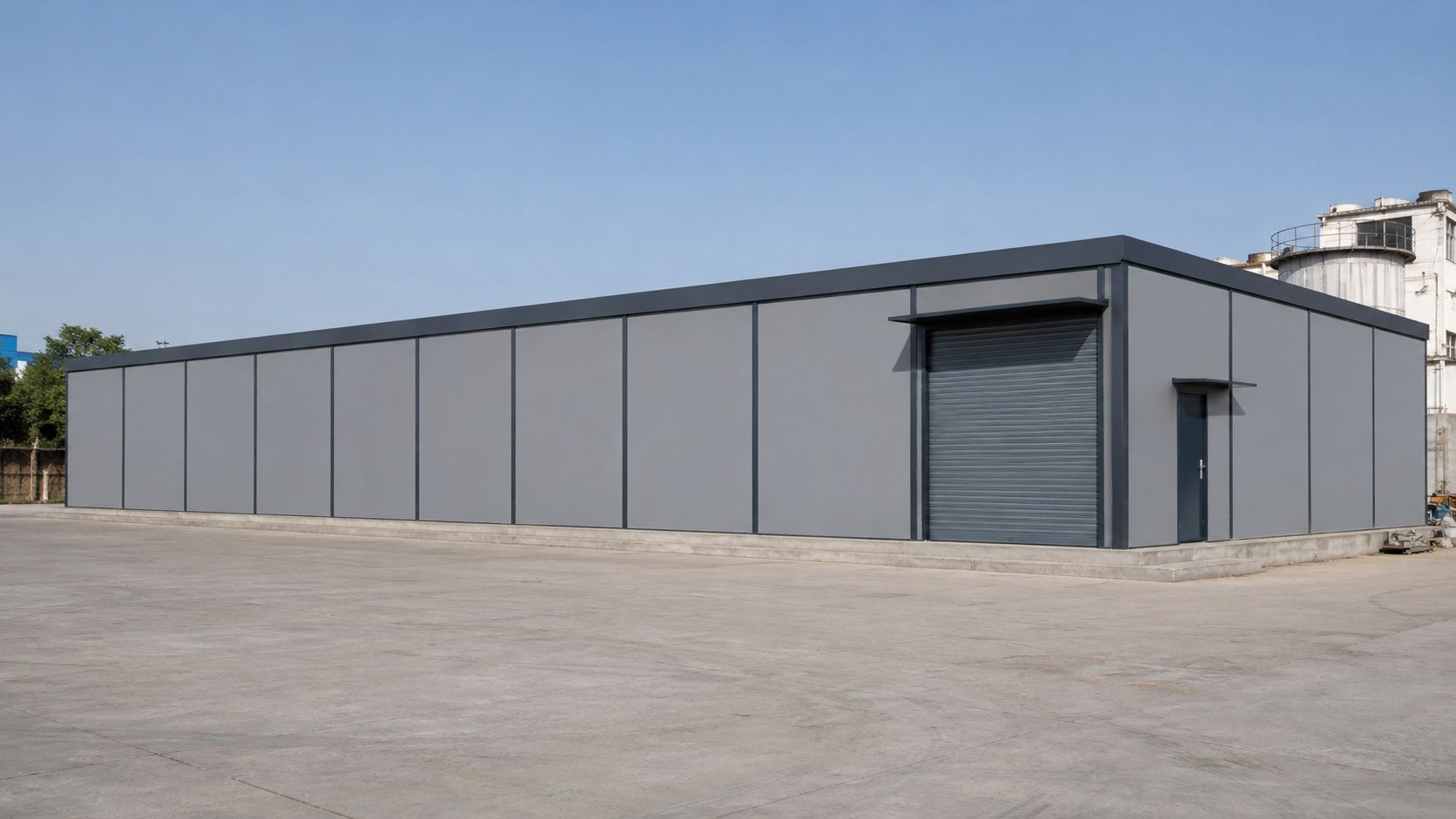 Steel-grey 120×30×20 ft prefab modular building with PUF panels on a concrete plinth.