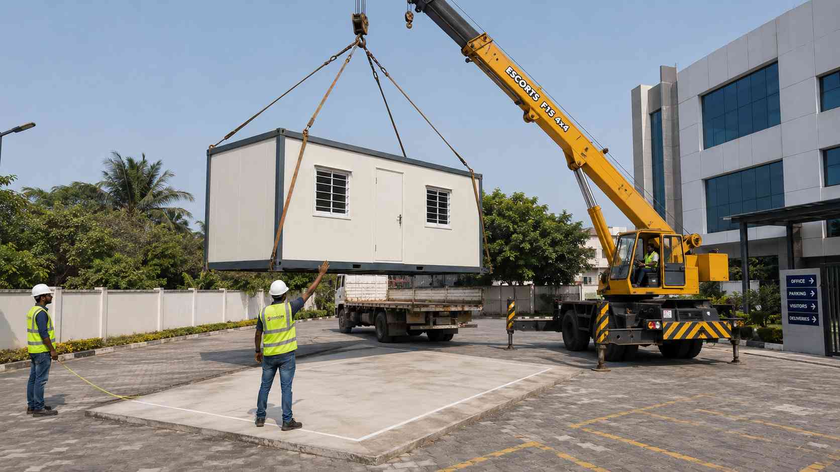 Crane placing a SAMAN prefab portable office onto a prepared surface at a business site on delivery day