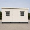 Side profile of SAMAN prefab portable office showing door, windows, sloped roof, and structural base