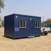 Navy blue prefab site office set up on a construction site in India.