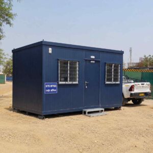 Navy blue prefab site office set up on a construction site in India.