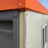 Close-up of a prefab site office insulated panel and bolted steel-frame join.