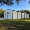 Side elevation of a white-and-charcoal prefabricated steel building showing its full length.
