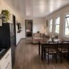 Warm taupe wood floor inside a fully fitted prefabricated container house living and dining area