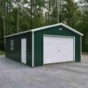 Forest green prefabricated industrial shed with a white garage door and side window on a cleared site.