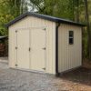 Pearl grey prefabricated industrial shed with anthracite roller door and a side personnel door.