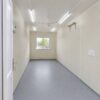 Interior of factory-fitted prefabricated portable office cabin with false ceiling tube lights ceiling fan and vinyl flooring