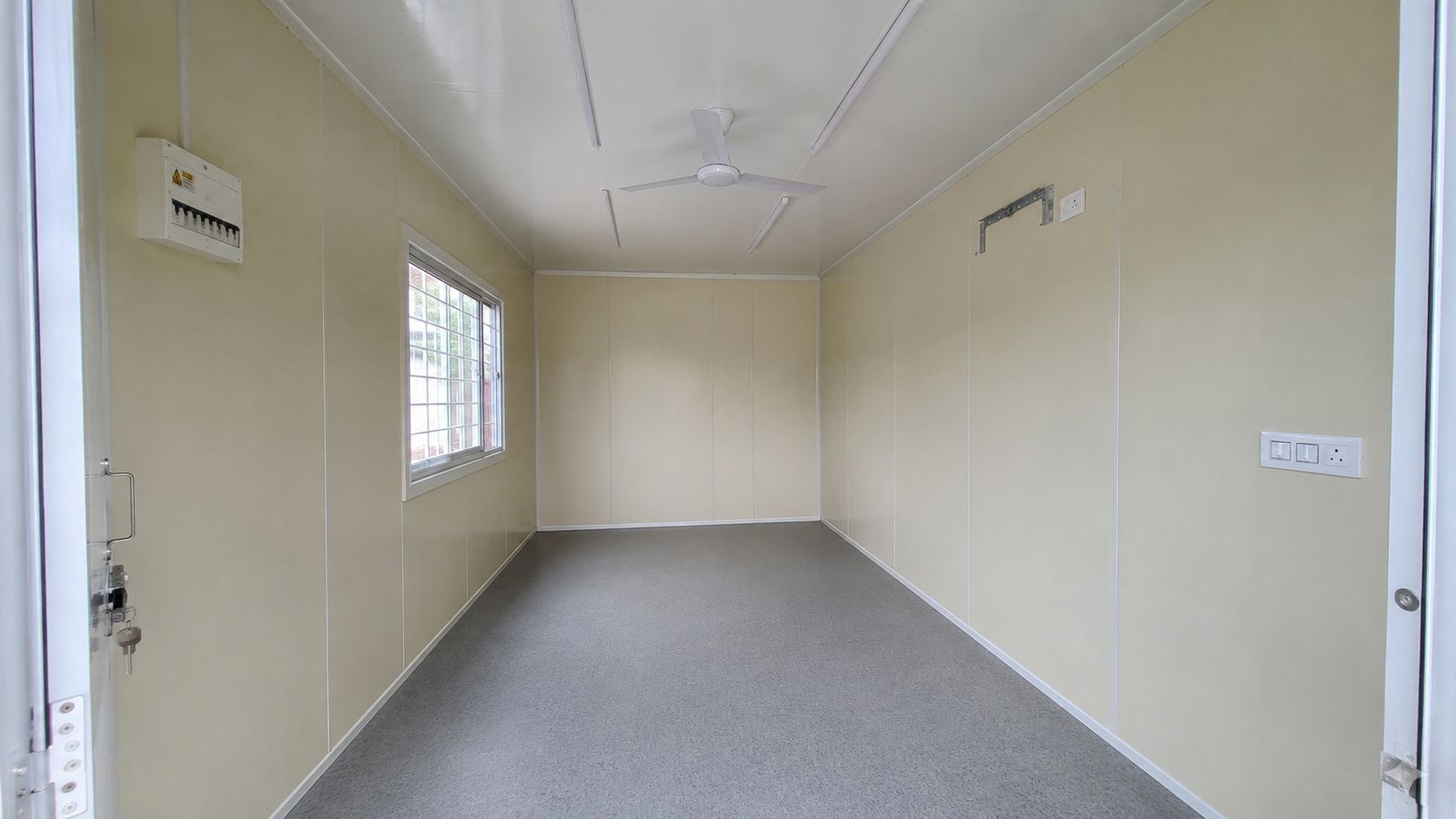 Interior of factory-fitted prefabricated portable office cabin showing electricals false ceiling and vinyl flooring