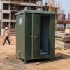 Forest green prefabricated toilet in use at an Indian construction site