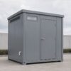 Steel grey prefabricated toilet unit side view showing door and roof vent