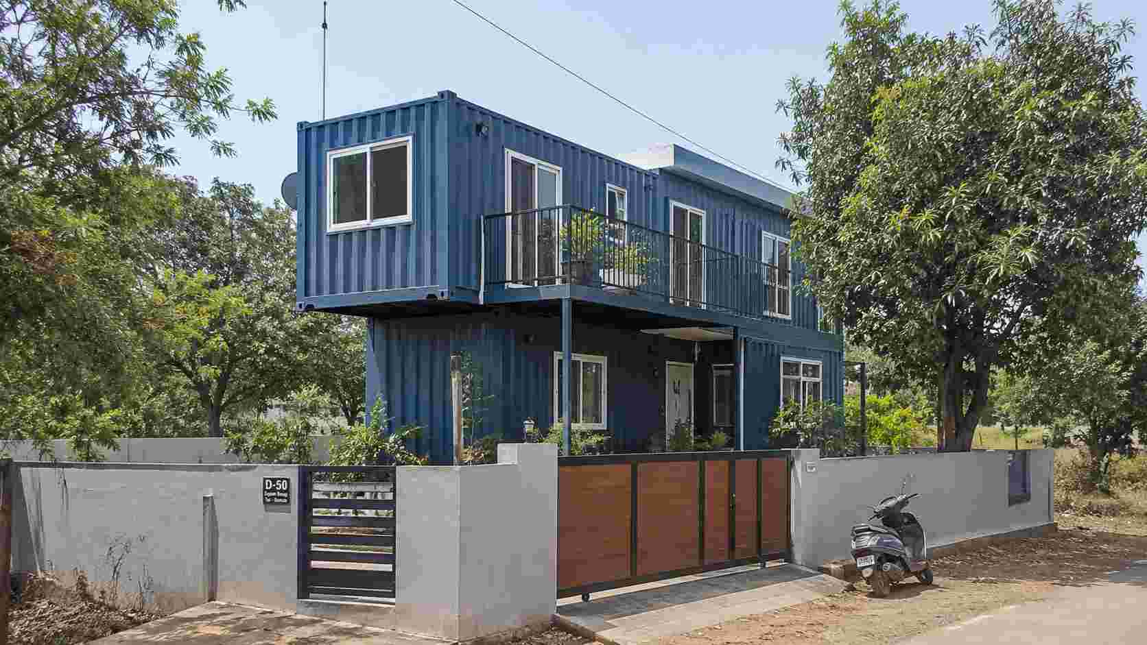 Steel-blue multi-container family home on a walled Indian residential plot