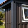 shipping container tiny house exterior corner detail showing slate charcoal steel frame and white window reveal
