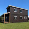 shipping container tiny house side view showing full 40ft depth with sandstone trim and green lawn