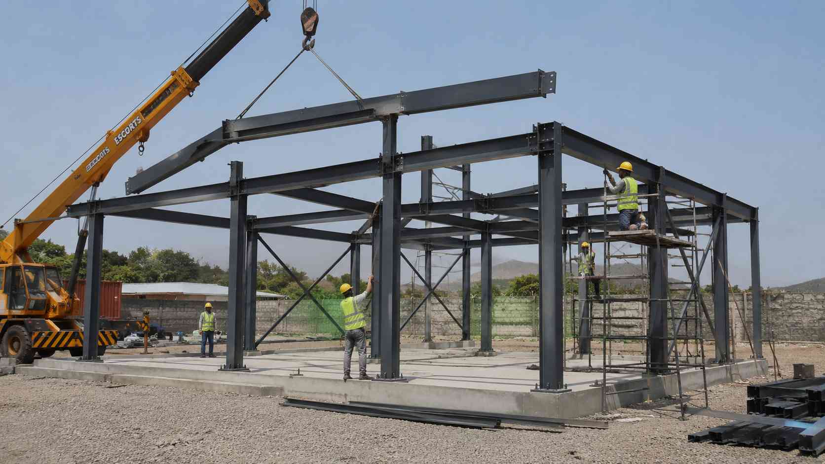  Slate charcoal structural steel frame of a prefab building being bolted together with a crane on site.
