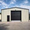 Sage-green steel shed front elevation with black roller shutter and matching personnel door