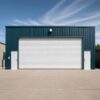 Teal steel shed with a wide roller door open onto a concrete workshop apron