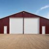 Burgundy 60×36 ft steel storage shed with a large white sliding door on a cleared site.