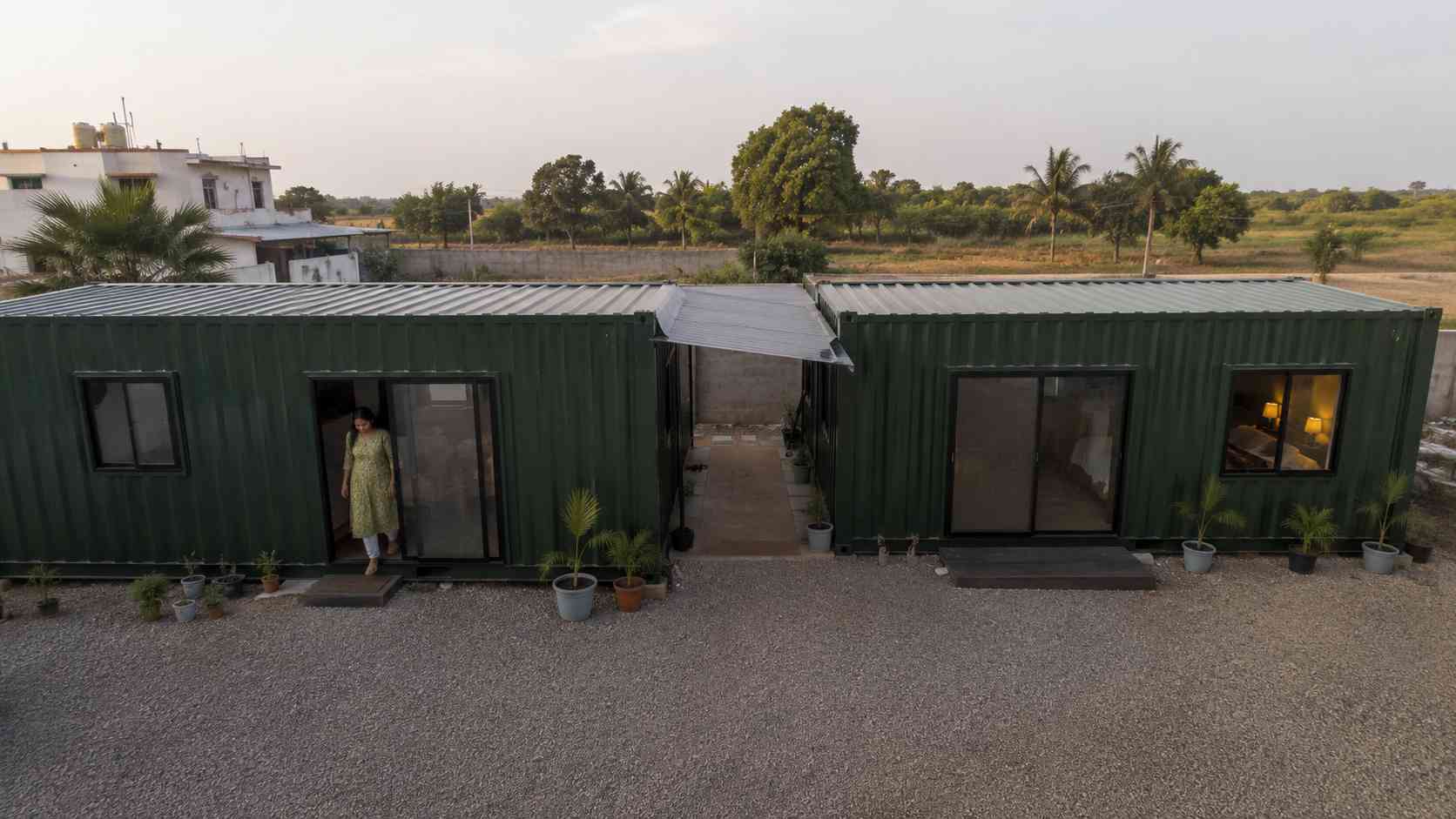 Two SAMAN tiny container homes placed side by side on an Indian farmland plot showing expandable two-unit configuration