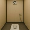 Indian-style toilet porta cabin interior with exhaust fan