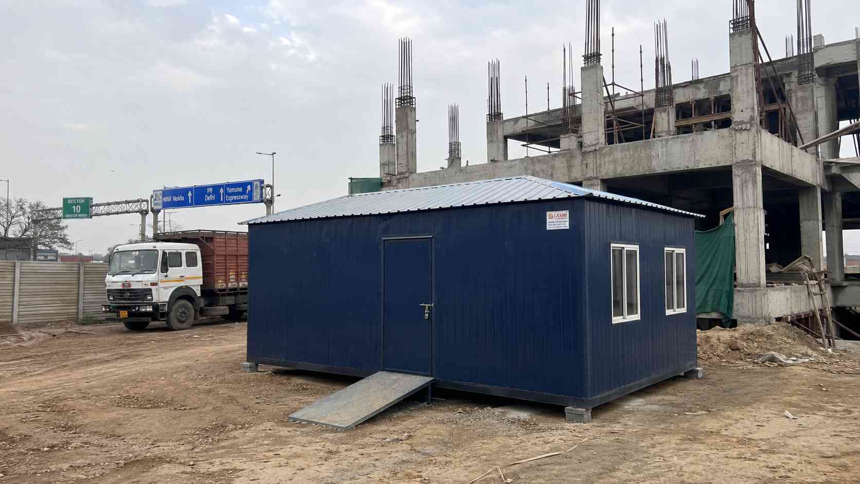 SAMAN porta cabin in Navy Blue exterior on a Greater Noida industrial site, ready for use as a site office.