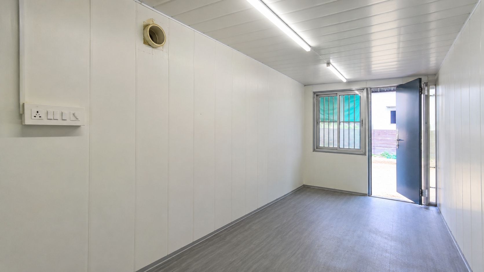  Interior of a 20ft factory-fitted Pure White #F5F2EB container office showing wall panels, electricals, flooring and AC provision.