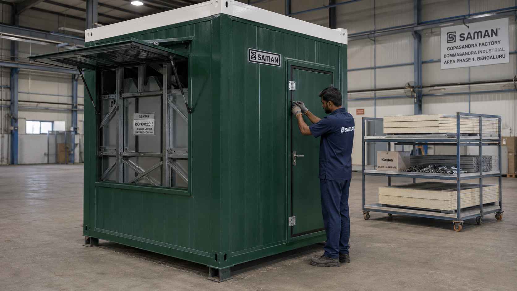 Bottle green SAMAN porta cabin on the Gopasandra factory floor in Bommasandra Industrial Area Phase 1 with IS 2062 frame visible during quality inspection