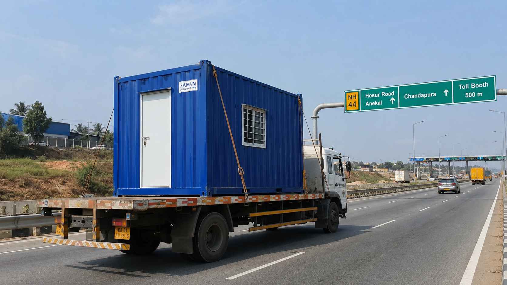 Royal Cobalt SAMAN porta cabin on a flatbed truck on NICE Road heading from Gopasandra factory to a KIADB Anekal plot.