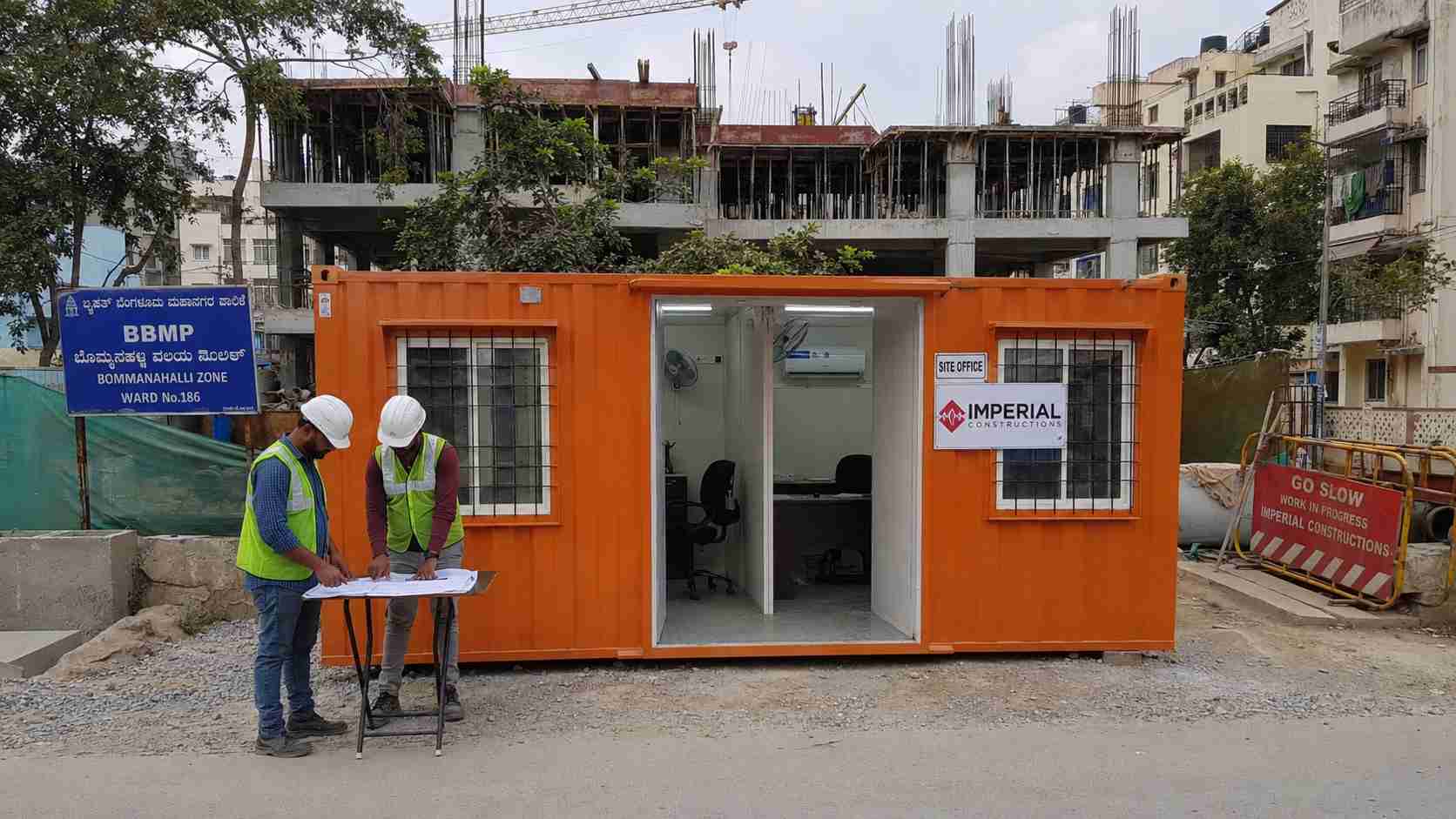 Safety Orange 20x10 ft two-compartment porta cabin on BDA apartment redevelopment site in HSR Sector 3