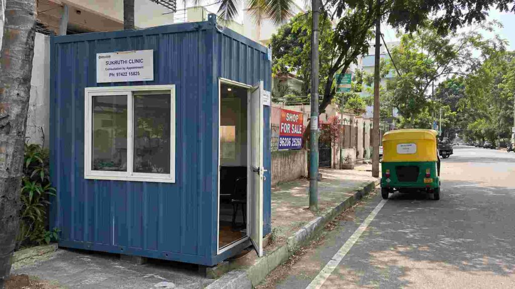 Steel Blue porta cabin on a Banashankari BDA-Stage commercial plot frontage, south Bangalore residential street context.