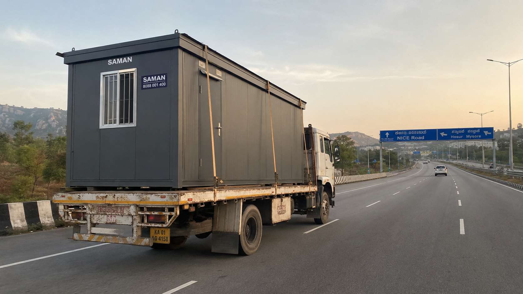 Anthracite Grey porta cabin in transit from SAMAN's Gopasandra factory to Jayanagar via NICE Road.