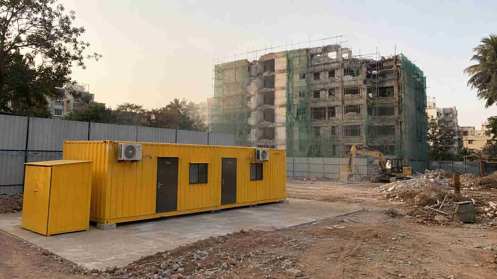 Industrial Yellow SAMAN 20×10 ft multi-room porta cabin used as a JP Nagar apartment-redevelopment builder site office.