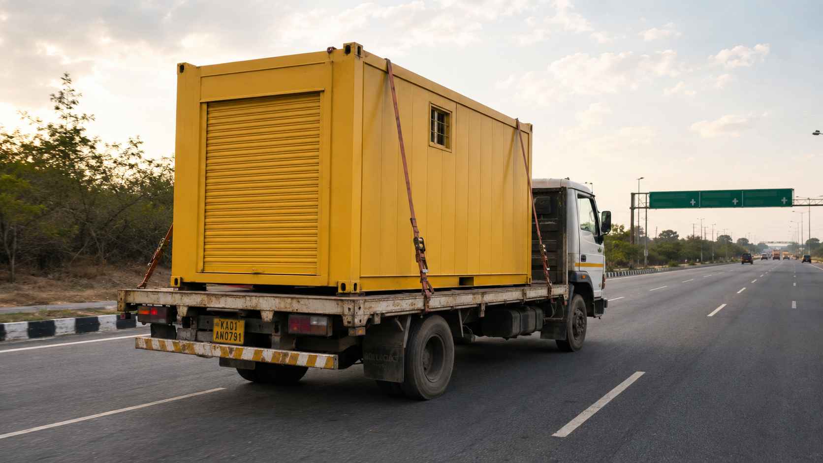 Industrial Yellow porta cabin in transit on the NICE Peripheral Ring Road approaching Kengeri at late afternoon.