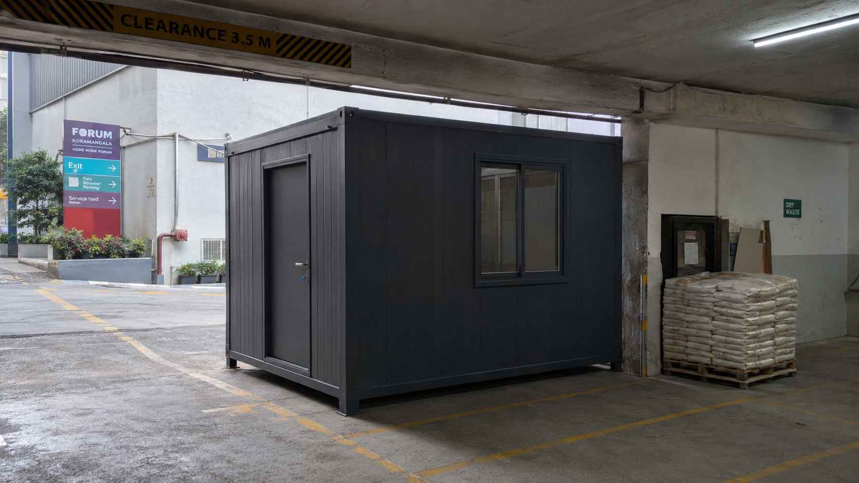 A Slate Charcoal mini porta cabin parked inside a Koramangala mall service-yard at the entry portal.